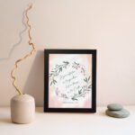 Infidu Set Your Affection On Things Above Bible Wall Art with floral wreath and pink background. displayed on the wall in a black frame