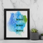 Bible wall art featuring the phrases Start With Jesus, Stay With Jesus, and End With Jesus in cursive on a watercolor blue and green background. displayed on the wall in a black frame