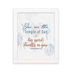 Christian wall art with You are the Temple of God in blue calligraphy and decorative blue dot patterns on a white background. hung on the wall in a white frame