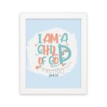 I Am a Child of God Christian Wall Art in bright orange and turquoise with a pastel blue background, perfect for home decor. hung on the wall in a white frame