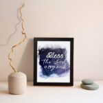 Bless The Lord O My Soul Psalm 103:1 Christian wall art with white text on a deep blue watercolor background. displayed on the wall in a black frame