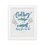 Proverbs 4:7 Christian wall art with elegant script and floral design, featuring Getting Wisdom Is The Wisest Thing You Can Do. hung on the wall in a white frame