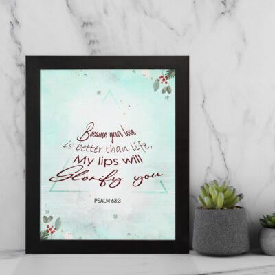 Because Your Love Is Better Than Life Psalm 63:3 Bible Verse Wall Art with soft blue background and floral accents. displayed on the wall in a black frame