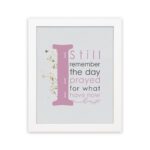 Christian wall art featuring the phrase 'I Still Remember The Days I Prayed For What I Have Now' with pink and gray text and gold flowers. hung on the wall in a white frame