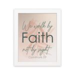 Christian wall art displaying the quote We Walk By Faith Not By Sight in elegant fonts on a soft beige-pink background. hung on the wall in a white frame