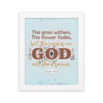 The Grass Withers Christian wall art with the verse Isaiah 40:8 in a modern font, featuring floral illustrations and a light blue background. hung the wall in a white frame