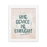 Christian wall art featuring the phrase His Grace Is Enough in teal lettering on a soft pink background with decorative swirls. hung on the wall in a white frame