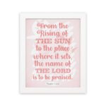 Bible wall art featuring Psalm 113:3 with bold text and a soft pink background, highlighting The Sun and The Lord. hung on the wall in a white frame