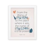 Bible verse wall art displaying From the Rising of the Sun to the Place Where It Sets, The Name of the Lord Is to Be Praised. hung on the wall in a white frame