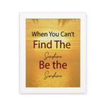 Infidu When You Can't Find The Sunshine Be The Sunshine wall art with a yellow background brown text and white frame hung on the wall. perfect for inspiring positivity in any workspace.