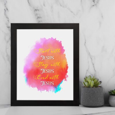 Bible wall art featuring Start With Jesus, Stay With Jesus and End With Jesus in white and orange fonts over a pink, orange, and yellow watercolor background. displayed on the wall in a black frame