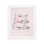 Infidu Take A Small Step Everyday wall art with a gray and light pink background black and red text and a white frame hung on the wall. Inspiring decor for any workspace.