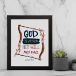 Wall art with the text 'God Is Within Her, She Will Not Fall' in colorful fonts, surrounded by pink blossoms and a wooden frame. displayed on the wall in a black frame