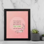 And Everyone Who Calls On The Name Of The Lord Will Be Saved Acts 2:21 Bible Verse Wall Art with pink flowers and soft pink background. displayed on the wall in a black frame