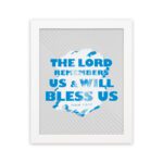 Wall art featuring the text The Lord Remembers Us And Will Bless Us in bold blue on a soft gray background. hung on the wall in a white frame