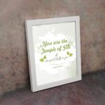 Christian wall art featuring 'You Are The Temple of God His Spirit Dwells in You' from 1 Corinthians 3:16 with green and gray design. displayed on the wall in a white frame