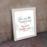 Christian wall art with You are the Temple of God in blue calligraphy and decorative blue dot patterns on a white background. displayed on the wall in a white frame