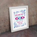 Infidu You Are The Temple Of God 1 Corinthians 3:16 Bible Wall Art with watercolor flowers and bold scripture design displayed on the wall in a white frame