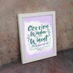 Christian wall art with Getting Wisdom Is The Wisest Thing You Can Do Proverbs 4:7, green text, light purple background, and decorative swirls. displayed on the wall in a white frame