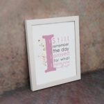 Christian wall art featuring the phrase 'I Still Remember The Days I Prayed For What I Have Now' with pink and gray text and gold flowers. displayed on the wall in a white frame