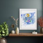 God Is Within Her She Will Not Fall Psalm 46:5 Bible Verse Wall Art with bright colors and watercolor background displayed on the wall in a white frame