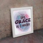 His Grace Is Enough Christian wall art with bold dark purple text and a soft gradient background in pink, purple, and blue. displayed on the wall in a white frame