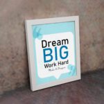 Infidu Dream Big Work Hard Make It Happen wall art with a sky blue and white background and sky blue and black text and white frame on the wall. Inspiring decor for home offices and workspaces.