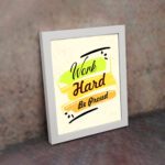 Infidu motivational quotes wall art featuring Work Hard Be Proud on a light white background with light gray flowers and a white frame on the wall. the inspiring success