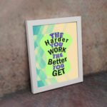 Infidu The Harder You Work The Better You Get wall art with a sandal-colored background green design, and white frame on the wall. Inspiring decor for home offices and workspaces.