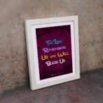 Infidu Bible Wall Art with the text The Lord Remembers Us and Will Bless Us in blue, yellow, and white on a purple background. displayed on the wall in a white frame