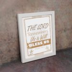 Infidu The Lord Remembers Us And Will Bless Us Psalm 115:12 Bible wall art with elegant text and plant border. displayed on the wall in a white frame