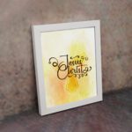 Jesus Christ Bible Wall Art in black script with a yellow cross and watercolor background, framed in black. Perfect Christian home decor. displayed on the wall in a white frame