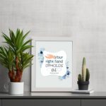 Your Right Hand Upholds Me Psalm 63:8 Christian wall art with a hand illustration and floral accents on a light gray background. displayed on the table in a white frame