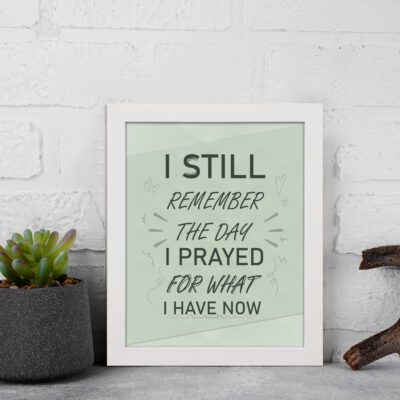 Christian wall art with the phrase I Still Remember The Days I Prayed For What I Have Now on a light green background. displayed on the wall in a white frame