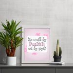 Christian wall art displaying We Walk By Faith Not By Sight with floral elements on a pale pink background. displayed on the table in a white frame