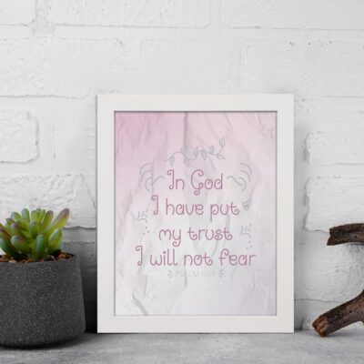 Christian wall art featuring Psalm 56:4, with soft pink background and elegant script font. Perfect for home decor. displayed on the wall in a white frame