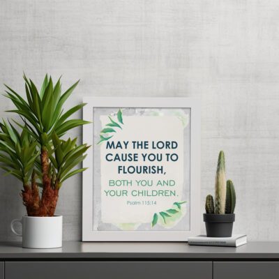 Infidu Christian wall art featuring Psalm 115:14 with bold text, green highlights, and leaf designs on a light gray background. displayed on the table in a white frame