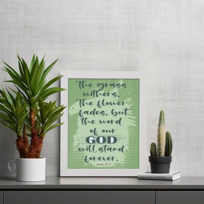 Christian wall art featuring Isaiah 40:8 with dark green and black text on a light green background. displayed on the table in a white frame