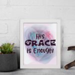 His Grace Is Enough Christian wall art with bold dark purple text and a soft gradient background in pink, purple, and blue. displayed on the wall in a white frame