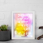 Christian wall art with Psalm 63:3, bold text in playful font, vibrant yellow, pink, and purple gradient on a warm background with a black frame. displayed on the wall in a white frame