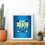 Infidu Dream Big Work Hard Make It Happen wall art with a blue background white, yellow, and black text, and a white frame on the table. Inspiring decor for home offices and workspaces.