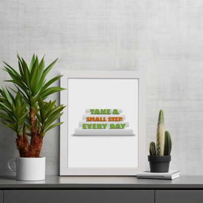 Infidu Take A Small Step Every Day wall art with a motivational quote and black frame on the table. Perfect decor for home offices and workspaces.