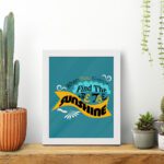 Infidu When You Can't Find the Sunshine, Be the Sunshine Office Wall Art featuring black, yellow, and blue text on a light blue background with decorative elements, framed in white on the table. Perfect for inspirational quote wall art, office wall art, and home decor.