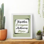 Infidu motivational quotes wall art featuring Together Everyone Achieves More on a light gray and light green background and white frame on the table. the inspiring teamwork