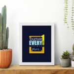 Infidu motivational quotes wall art featuring Together Everyone Achieves More on a navy blue background and white frame displayed on the table. Perfect for inspiring your workspace.