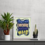 Infidu motivational quotes wall art featuring Together Everyone Achieves More on a white background with a navy blue design and gray shadow and white frame displayed on the table. the inspiring teamwork