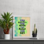 Infidu The Harder You Work The Better You Get wall art with a sandal-colored background green design, and a white frame on the table. Inspiring decor for home offices and workspaces.