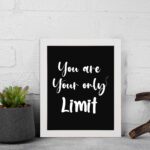 Infidu motivational quotes wall art featuring You Are Your Only Limit on a dark black background and white frame displayed on the wall. Perfect for inspiring your workspace.