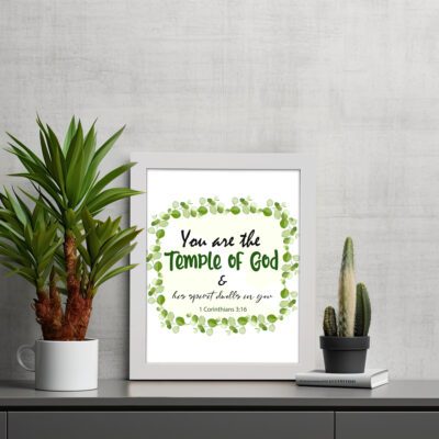 You Are The Temple Of God, His Spirit Dwells In You 1 Corinthians 3:16 Bible Verse Wall Art with green leaf wreath design. displayed on the table in a white frame