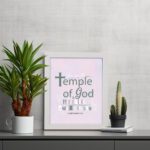 You Are The Temple of God 1 Corinthians 3:16 Christian Wall Art with soft pink background and elegant grey text. displayed on the table in a white frame